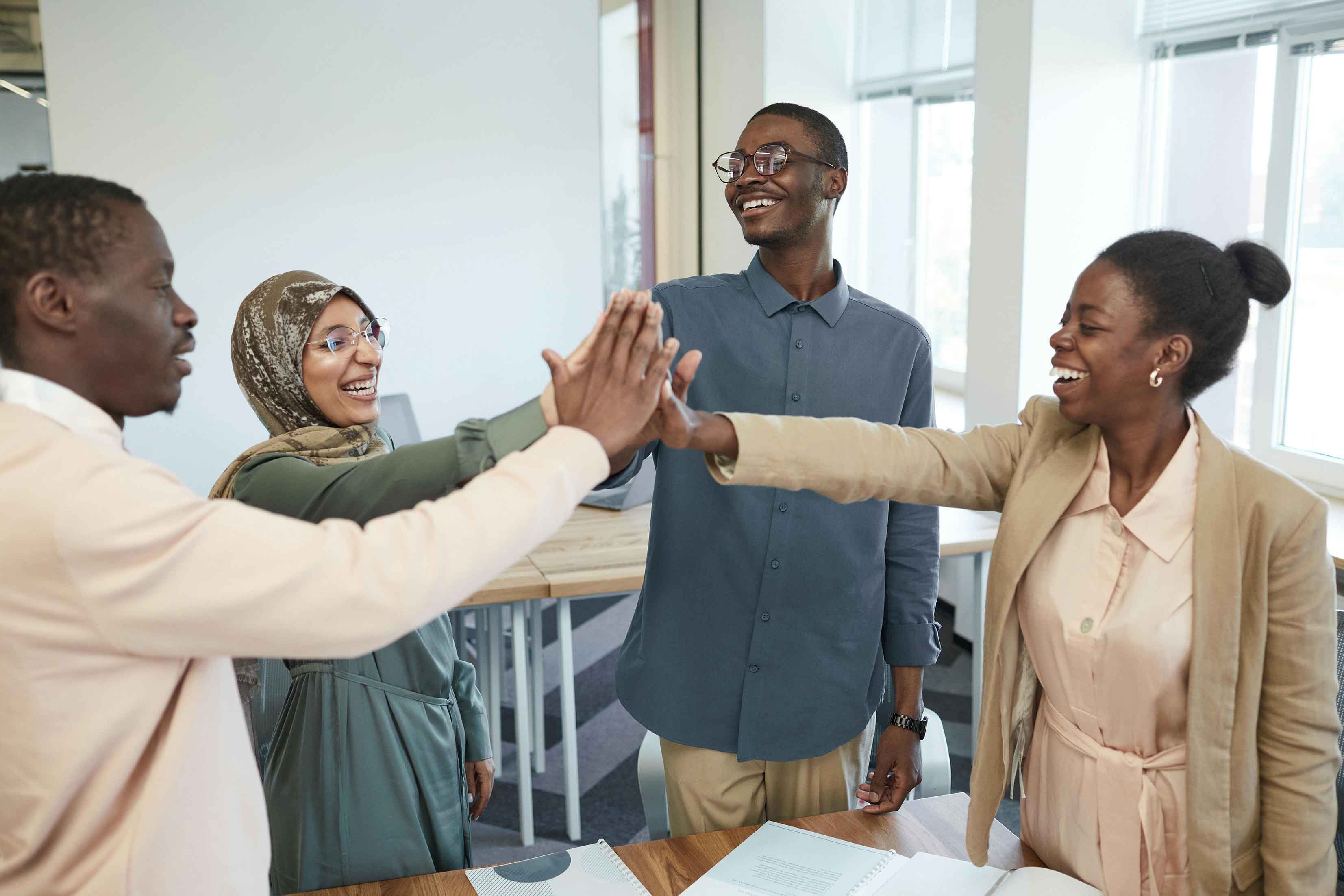 Four Smiling African Youth Hi-fiving